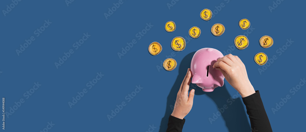 Fototapeta premium Person depositing money in a pink piggy bank