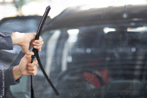 Technician replacing windshield wipers change car wiper blades photo