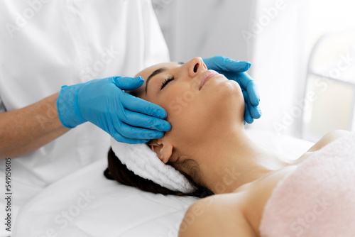 Pleasant beauty procedure with soft face massage performed by the professional therapist