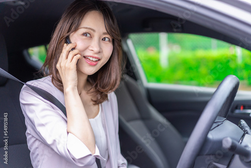 スマホを使いながら車を運転する女性
