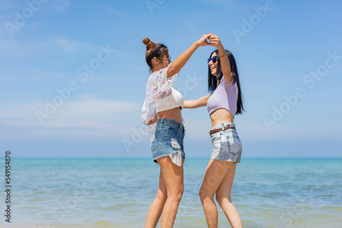 Two girlfriends hugging up and enjoying on the sea beach. A pair of girls in love cuddling on a tropical beach. romantic young lesbian couples in love and walking together on the beach.Concept of LGBT