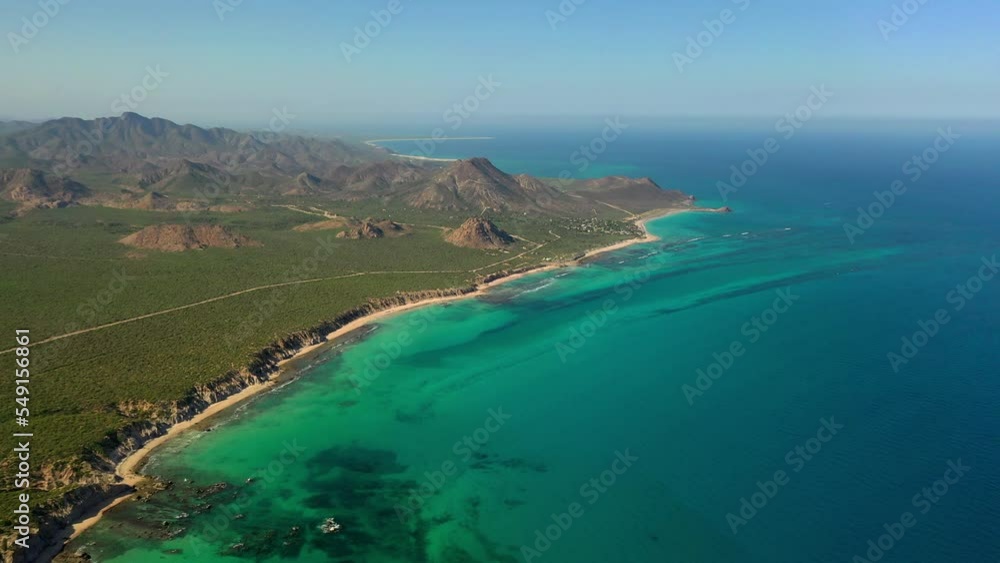 Aerial Beautiful View Of Mountains Against Clear Sky, Drone Flying Backwards Over Turquoise Sea - Baja California, Mexico Aerial Beautiful View Of Mountains Against Clear Sky, Drone Flying Backwards Over Turquoise Sea - Baja California, Mexico