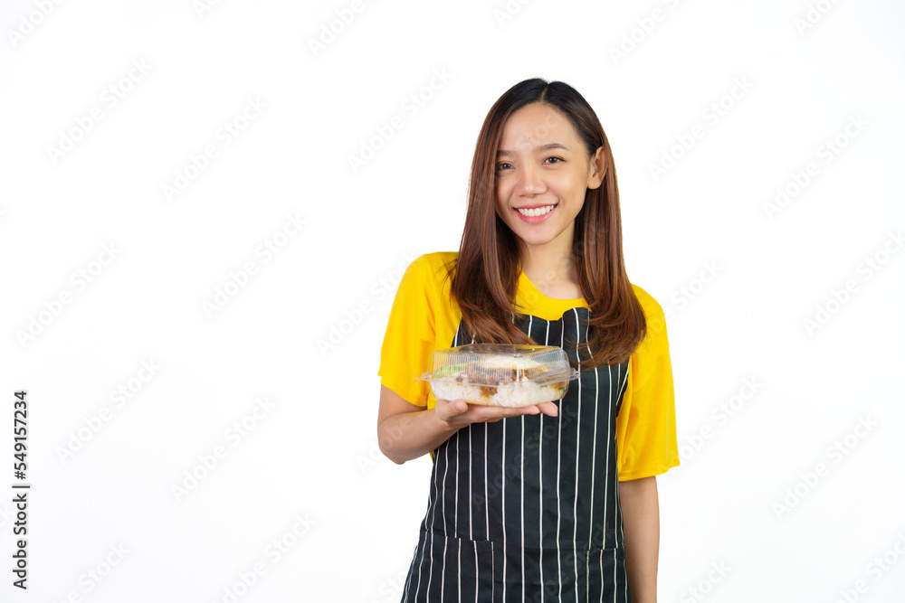 Holding Krapao (Thai food) box, Portrait of confident asian woman barista and food owner shop with yellow t-shirt and black apron standing on white background. Holding Krapao (Thai food) box, Portrait of confident asian woman barista and food owner shop with yellow t-shirt and black apron standing on white background.