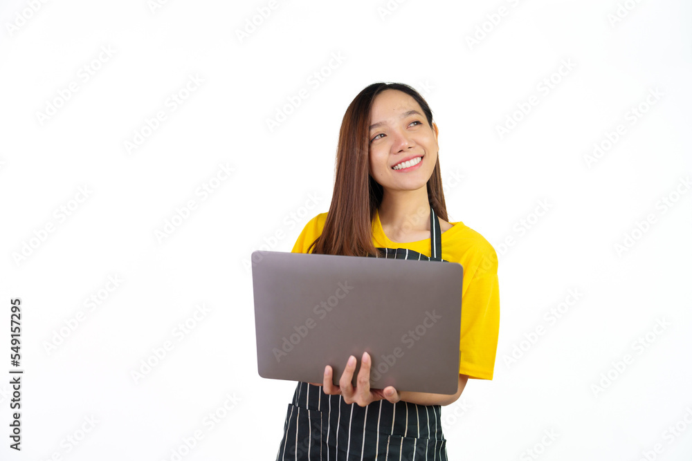 Using laptop, checking email or online order, Portrait of confident asian woman barista and food owner shop with yellow t-shirt and black apron standing on white background. Using laptop, checking email or online order, Portrait of confident asian woman barista and food owner shop with yellow t-shirt and black apron standing on white background.