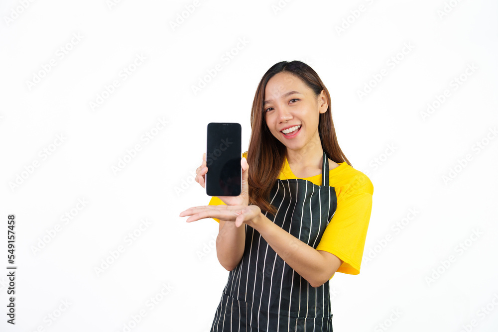 Showing blank screen mobile phone for display your ads, Portrait of confident asian woman barista and food owner shop with yellow t-shirt and black apron standing on white background. Showing blank screen mobile phone for display your ads, Portrait of confident asian woman barista and food owner shop with yellow t-shirt and black apron standing on white background.