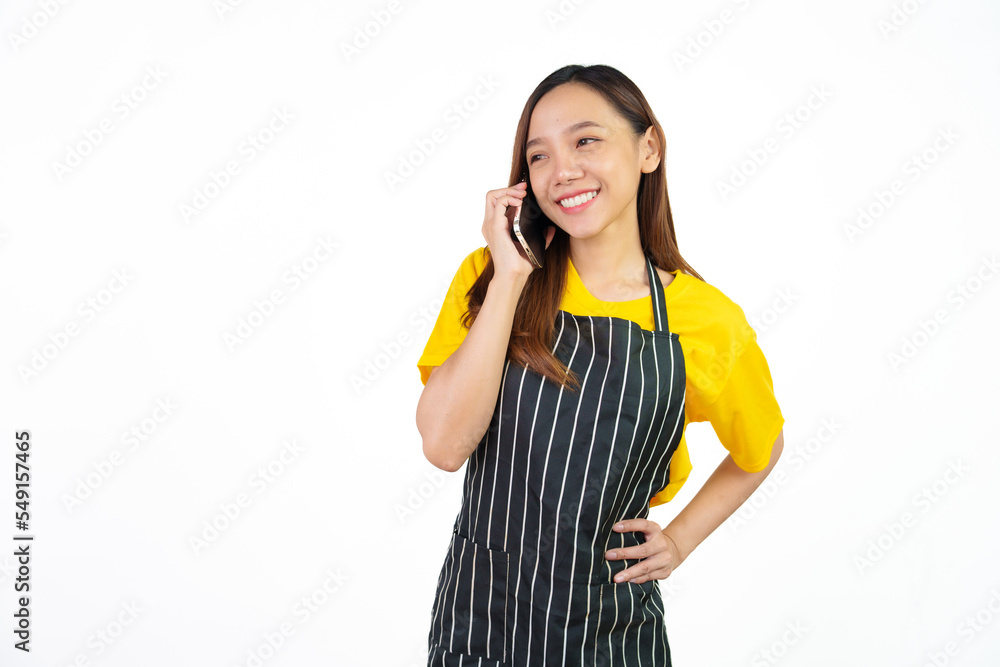 Talking or call mobile phone, Portrait of confident asian woman barista and food owner shop with yellow t-shirt and black apron standing on white background. Talking or call mobile phone, Portrait of confident asian woman barista and food owner shop with yellow t-shirt and black apron standing on white background.