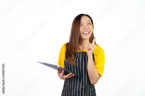 Holding menu on clipboard  Portrait of confident asian woman barista and food owner shop with yellow t-shirt and black apron standing on white background.