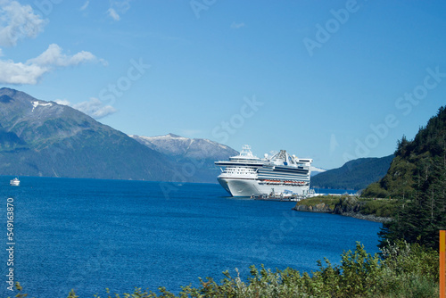 A large passenger ship in the water channel with snowy mountains in Alaska