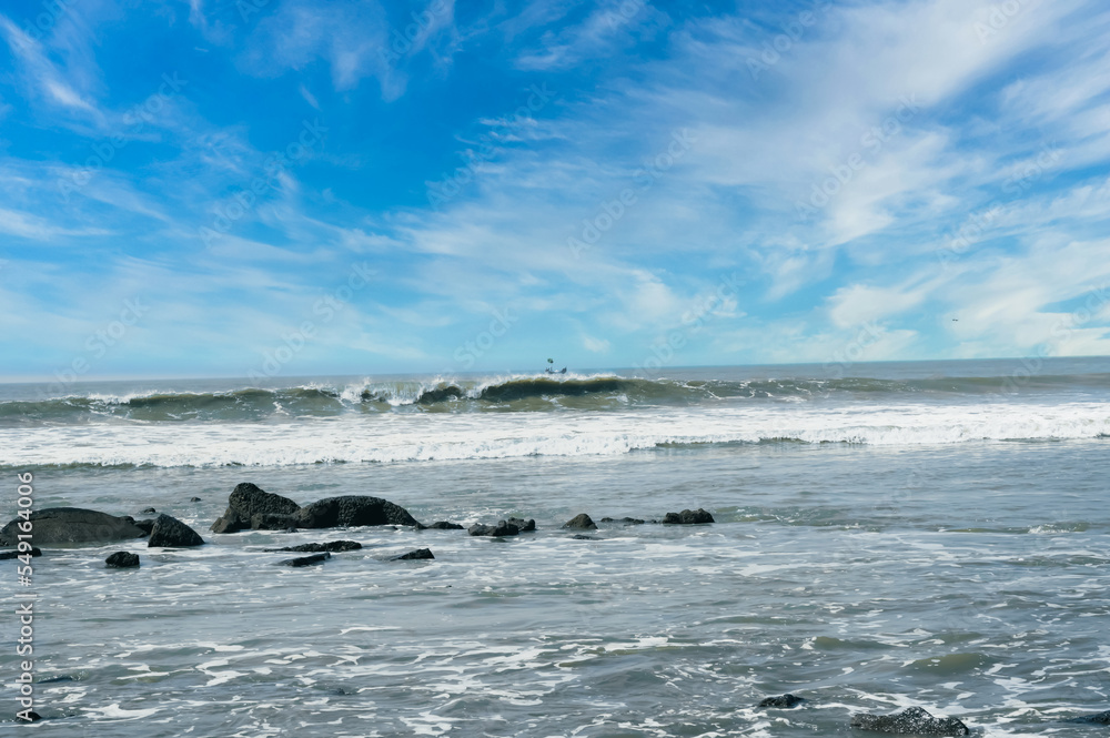Obraz premium The boat is moving through the middle of the sea. There are big waves in the sea.