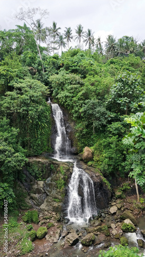 A waterfall in the tropical jungle. Water running down a rocky cliff