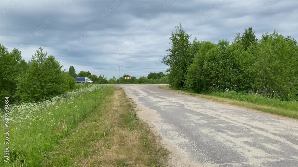 the car passes an intersection in a rural area. the van is on a road. the car passes an intersection in a rural area. the van is on a road.