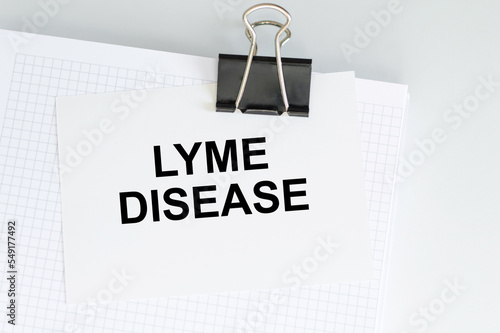 Lyme disease inscription on a card clip to a sheet of notepad on a light background