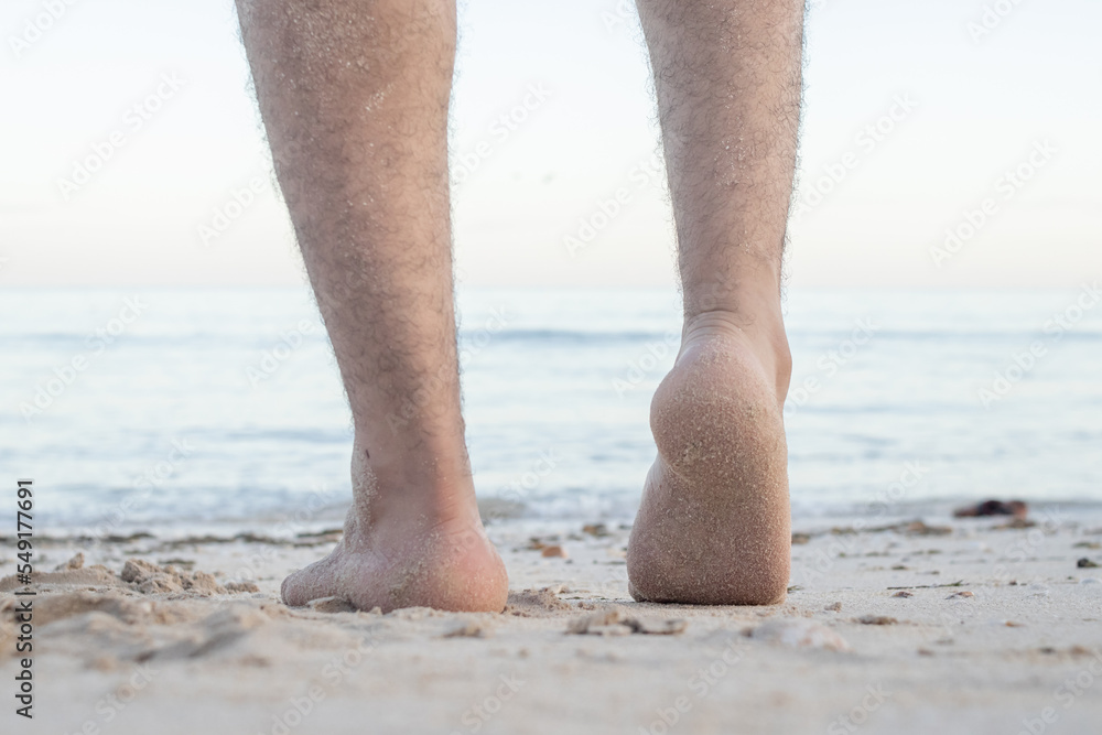 Barefoot male legs stand on the wet coastal sand on the shores of Puerto Progreso yucatan, mexico Barefoot male legs stand on the wet coastal sand on the shores of Puerto Progreso yucatan, mexico