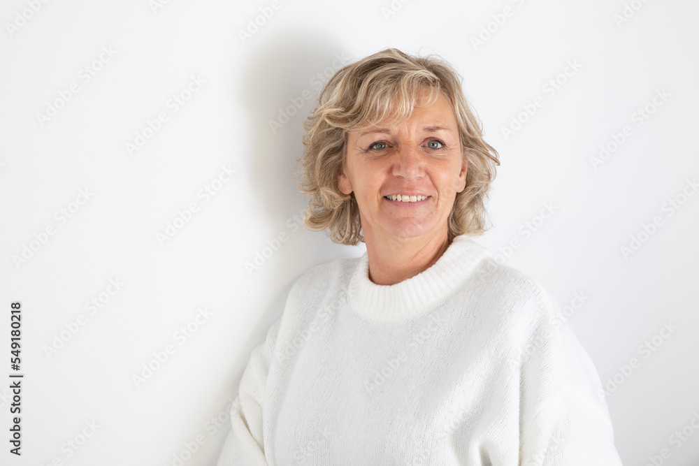portrait of fifties senior blond woman with curly blonde hair and blue eyes on white background portrait of fifties senior blond woman with curly blonde hair and blue eyes on white background