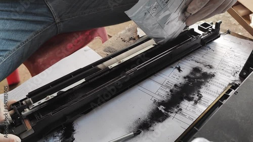 Expert technician is repairing a copier drum by replacing a new DV magnetic powder.