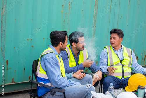 A Group of multiethnic male workers teams taking a break and rest sitting at the workplace