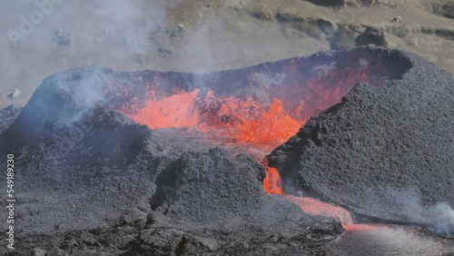 telephoto shot of lava magma boiling exploding in the volcano caldera slow motion,fagadralsfjall iceland photo