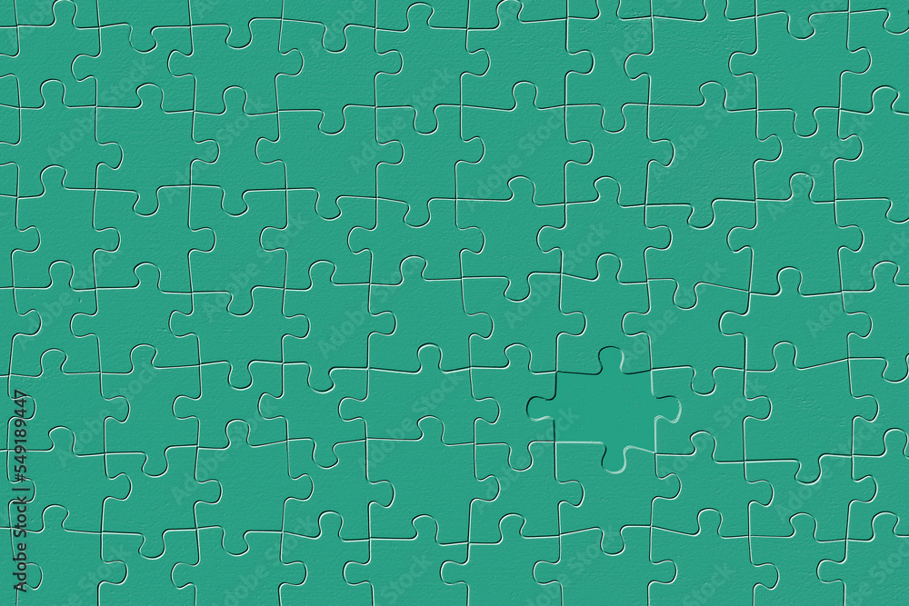 Embossed, missing piece of a green jigsaw puzzle.