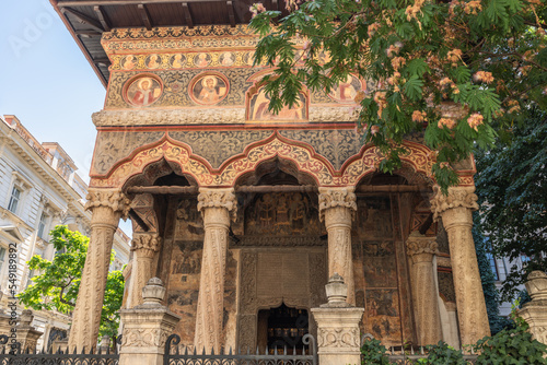 In remarkable Stavropoleos Church you admire the intricately carved wooden doors, carved sophisticated marble columns, saints painted on medalions and rails with griffins, Bucharest, Romania photo