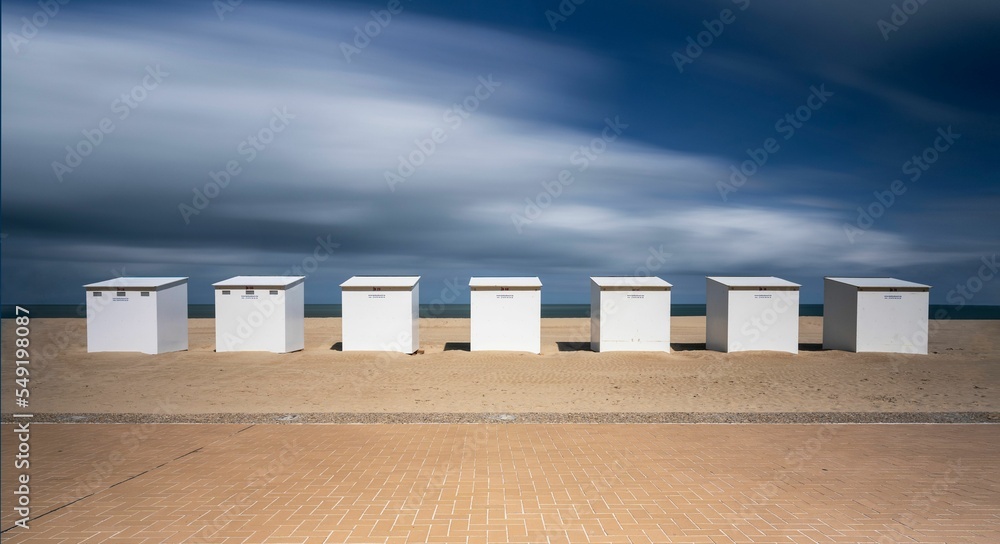Obraz premium Long exposure of a row of beach huts on the beach of the North Sea in Koksijde, Belgium