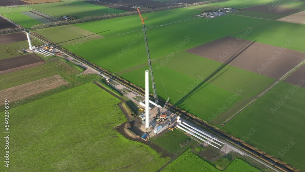 Construction site of a wind turbine windmill. Green energy generation in The Netherlands. Sustainable energy transistion in the making. Aerial drone view. Build using cranes. Green electric energy. Construction site of a wind turbine windmill. Green energy generation in The Netherlands. Sustainable energy transistion in the making. Aerial drone view. Build using cranes. Green electric energy.