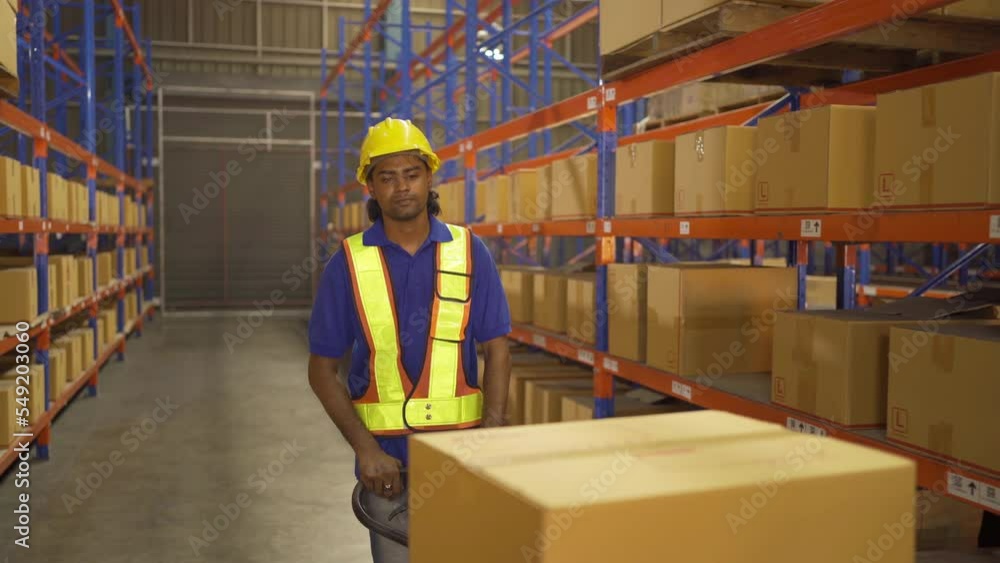 Portrait of Indian worker working in large warehouse retail store industry. Rack of stock storage. Interior of cargo in ecommerce and logistic concept. Depot. People lifestyle. Shipment service. Portrait of Indian worker working in large warehouse retail store industry. Rack of stock storage. Interior of cargo in ecommerce and logistic concept. Depot. People lifestyle. Shipment service.