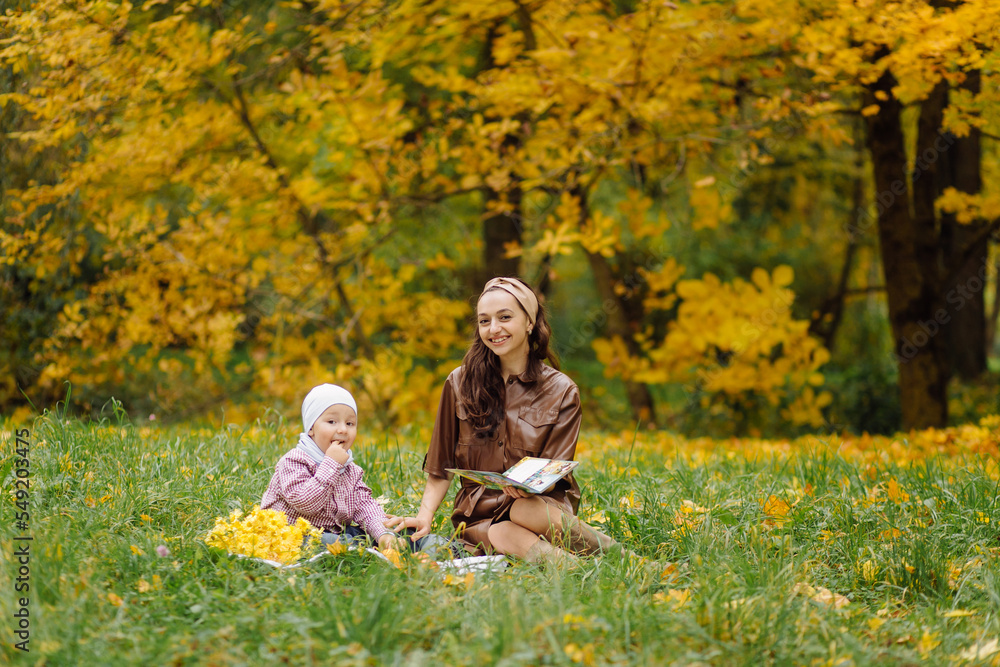 Fototapeta premium Mom and son walking and having fun together in the autumn park.