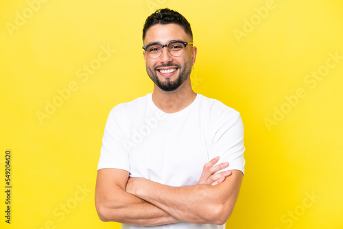Young Arab handsome man isolated on yellow background With glasses with happy expression