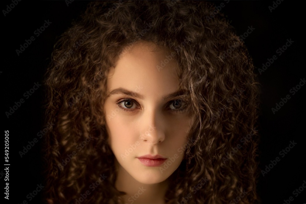 Curly beautiful girl on a black background