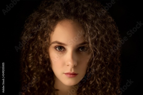 Curly beautiful girl on a black background