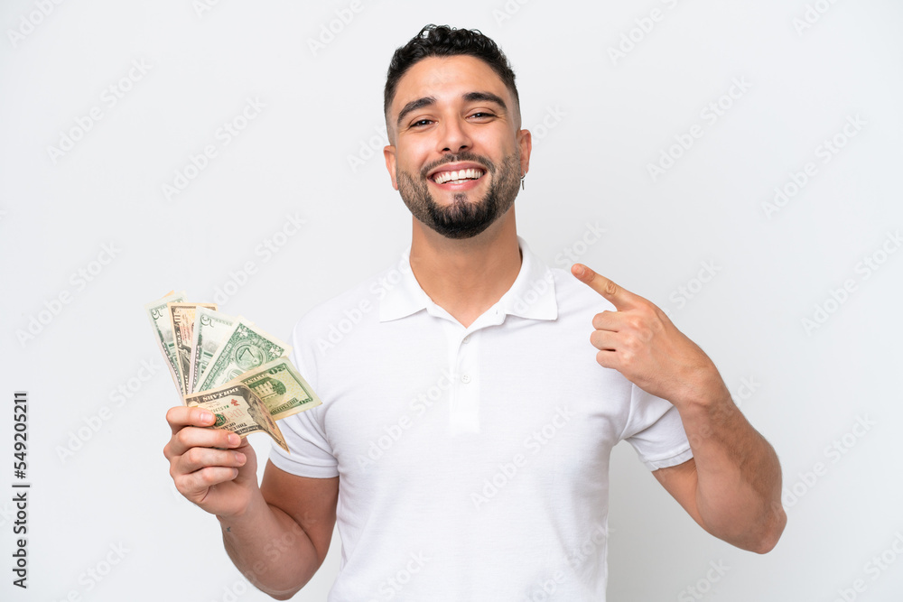 Young Arab man taking a lot of money isolated on white background giving a thumbs up gesture Young Arab man taking a lot of money isolated on white background giving a thumbs up gesture