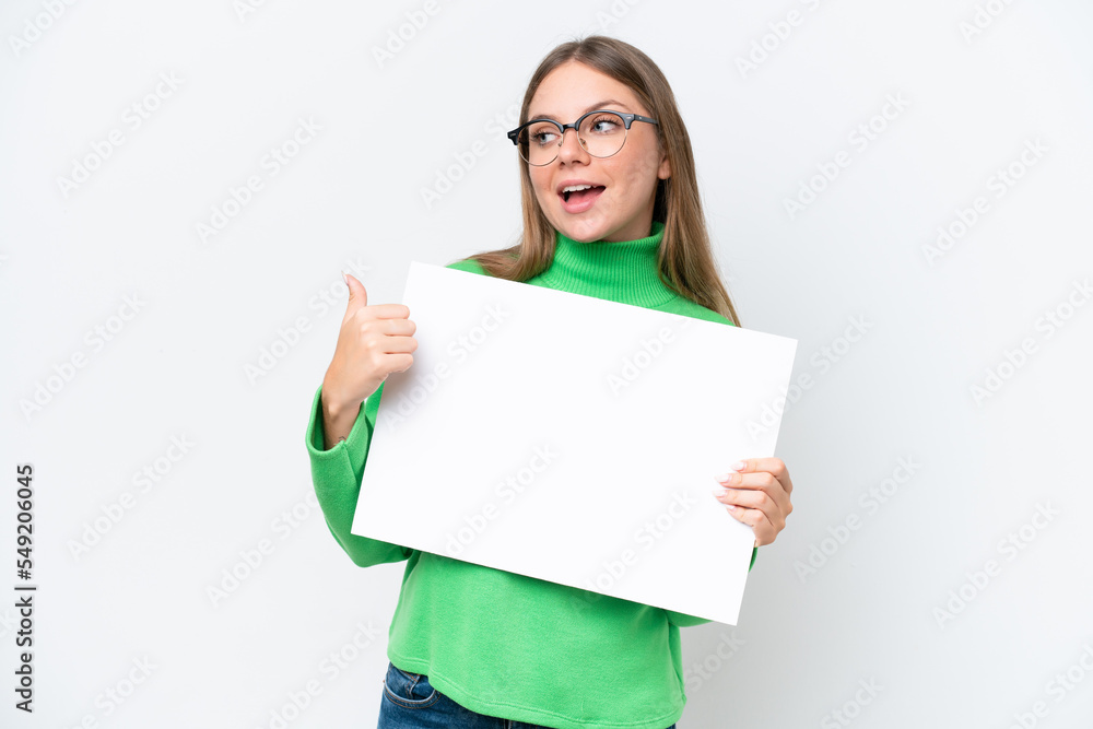 Young caucasian woman isolated on white background holding an empty placard and pointing side Young caucasian woman isolated on white background holding an empty placard and pointing side