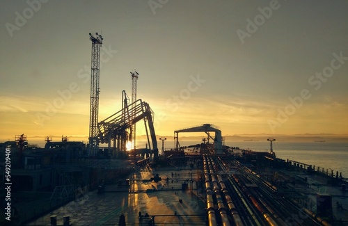 Aerial of pipelines and construction zones by the sea during sunset photo