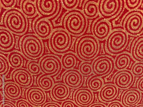 Background of swirl pattern on a chair in red and golden color.