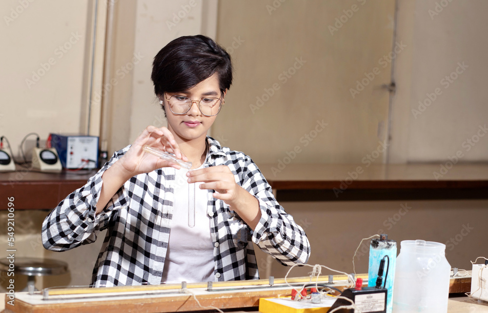 Indian girl student working or experimenting in science lab. Indian girl student working or experimenting in science lab.