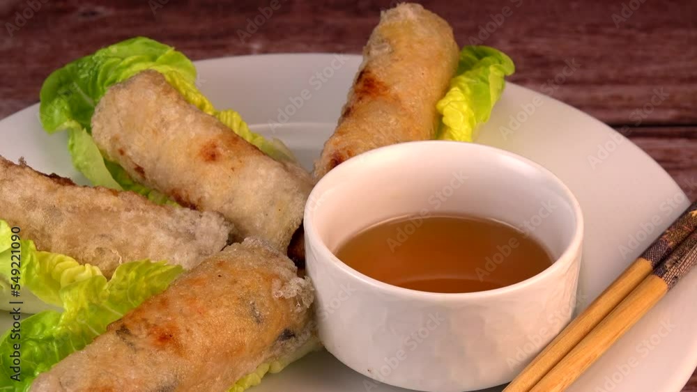 Vietnamese fried spring rolls with chicken on lettuce leaves and egg roll sauce, High quality 4k footage Vietnamese fried spring rolls with chicken on lettuce leaves and egg roll sauce, High quality 4k footage