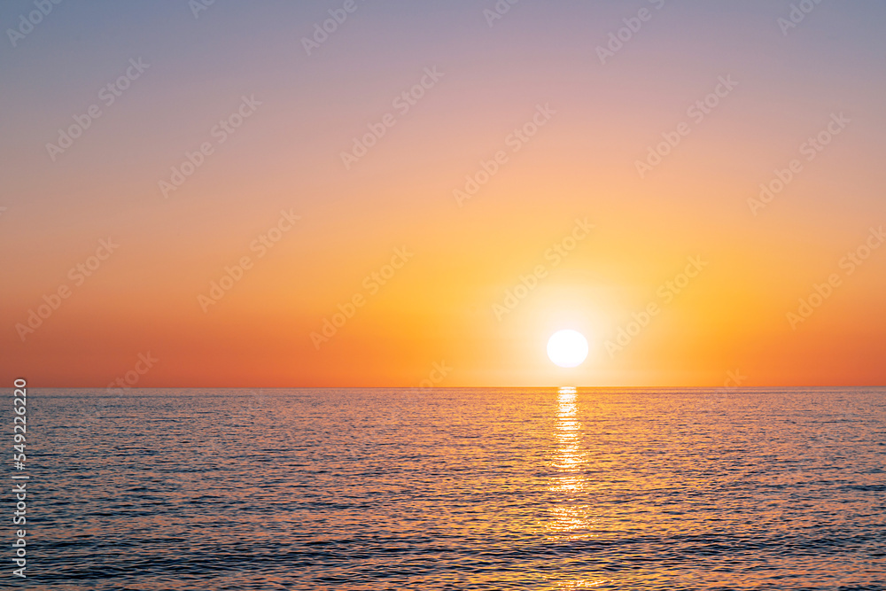 Beautiful golden sunset over the sea. Reflection of sun in the water.