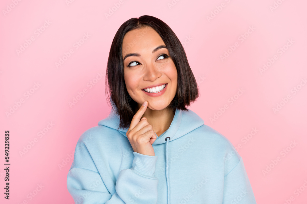 Fototapeta premium Photo of dreamy sweet lady wear blue hoodie finger chin looking empty space isolated pink color background
