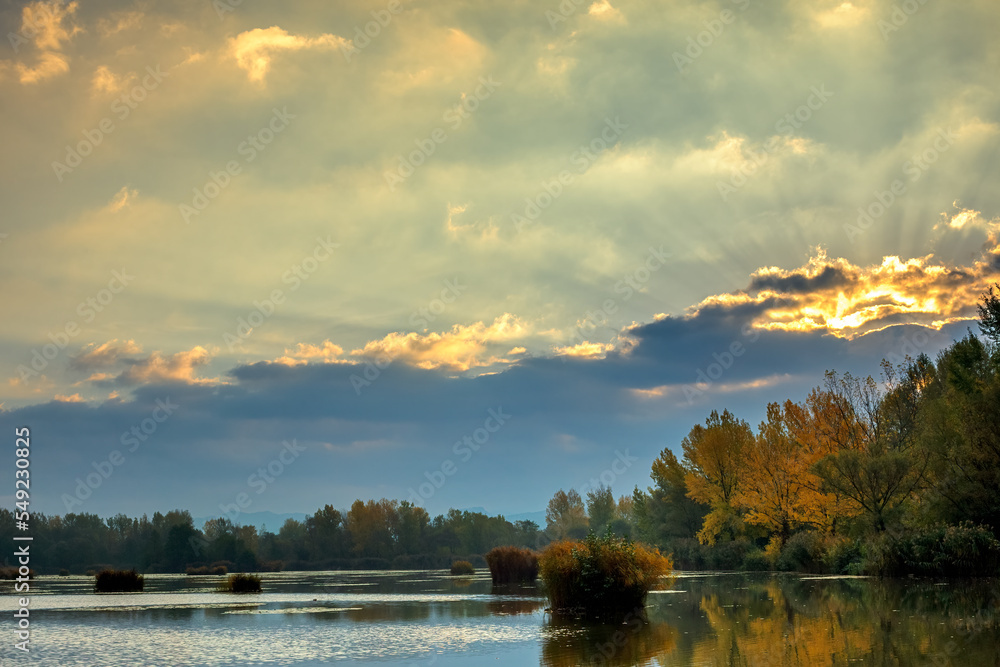 Fototapeta premium Sunrise over lake, sun hidden behind a cloud. Autumn landscape. Dubnica, Slovakia.
