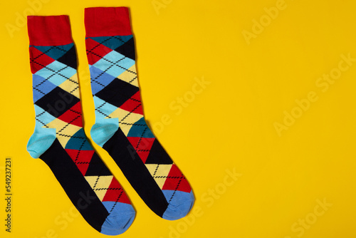 A pair of colored socks with rhombuses, on a yellow background