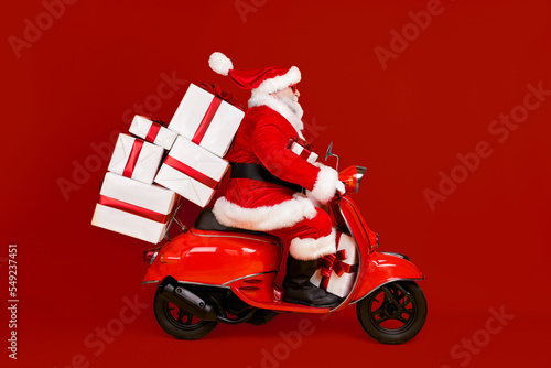 Profile side view of his he nice funny fat St Nicholas driving motor bike hurry up delivering pile stack gifts Eve Noel winter tradition isolated bright vivid shine vibrant yellow color background