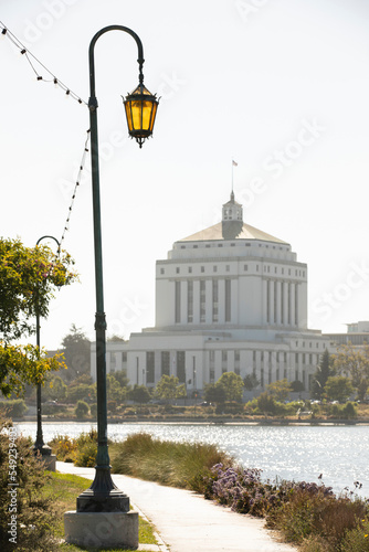 A historic street lamp frames the downtown skyline of Oakland, California, USA.