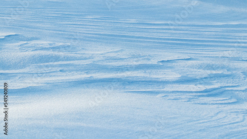 Snowy background, snow-covered surface of the earth after a blizzard in the morning in the sunlight with distinct layers of snow