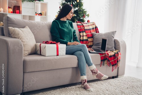 Photo of sweet shiny girl wear xmas green pullover buying gifts modern device indoors home room photo