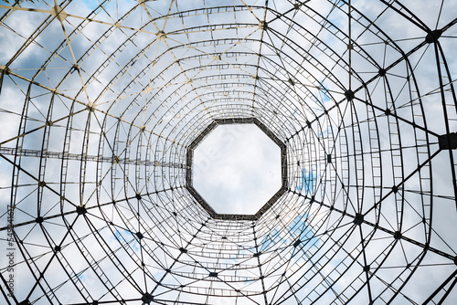 Bottom-up view of a steel structure against the sky. The concept of a radio telescope and astronomy or an abstract industrial pattern