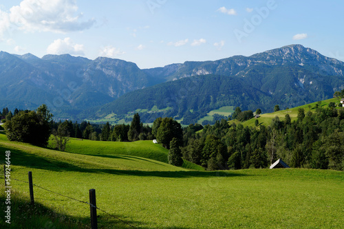 a hiking trail overlooking the picturesque alpine landscape with a vast green alpine valley in the Austrian Alps of the Schladming-Dachstein region (Schladming, Austria)