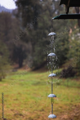 Vertical closeup of a rain chain with umbrellas against the autumn park photo