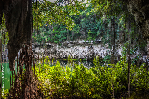 Exit from the water cave in the jungle to a small lake surrounded by mountains. Beautiful tropical nature. Cave with access to the water in the tropics.