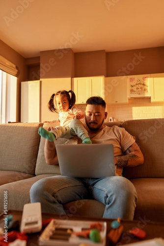 Girl climb down from father neck work on laptop