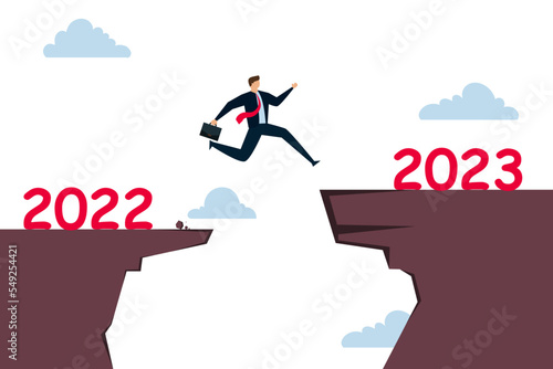 New year 2023 hope for business recovery, change year from 2020 to 2021 calendar or new challenge coming concept, confident success businessman attempt to jump high overcome risk to next cliff.